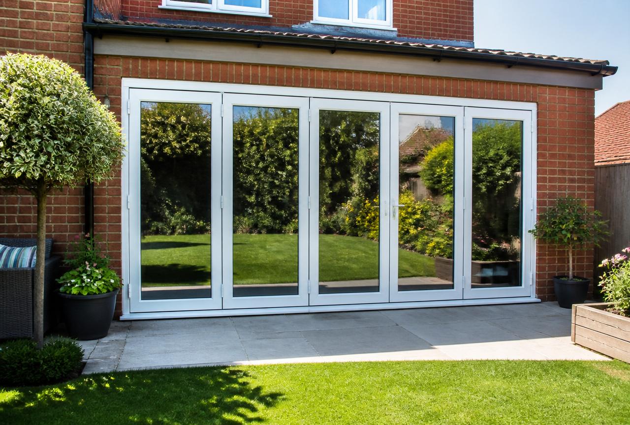 Bi-fold doors on a red brick UK house with a bright back garden